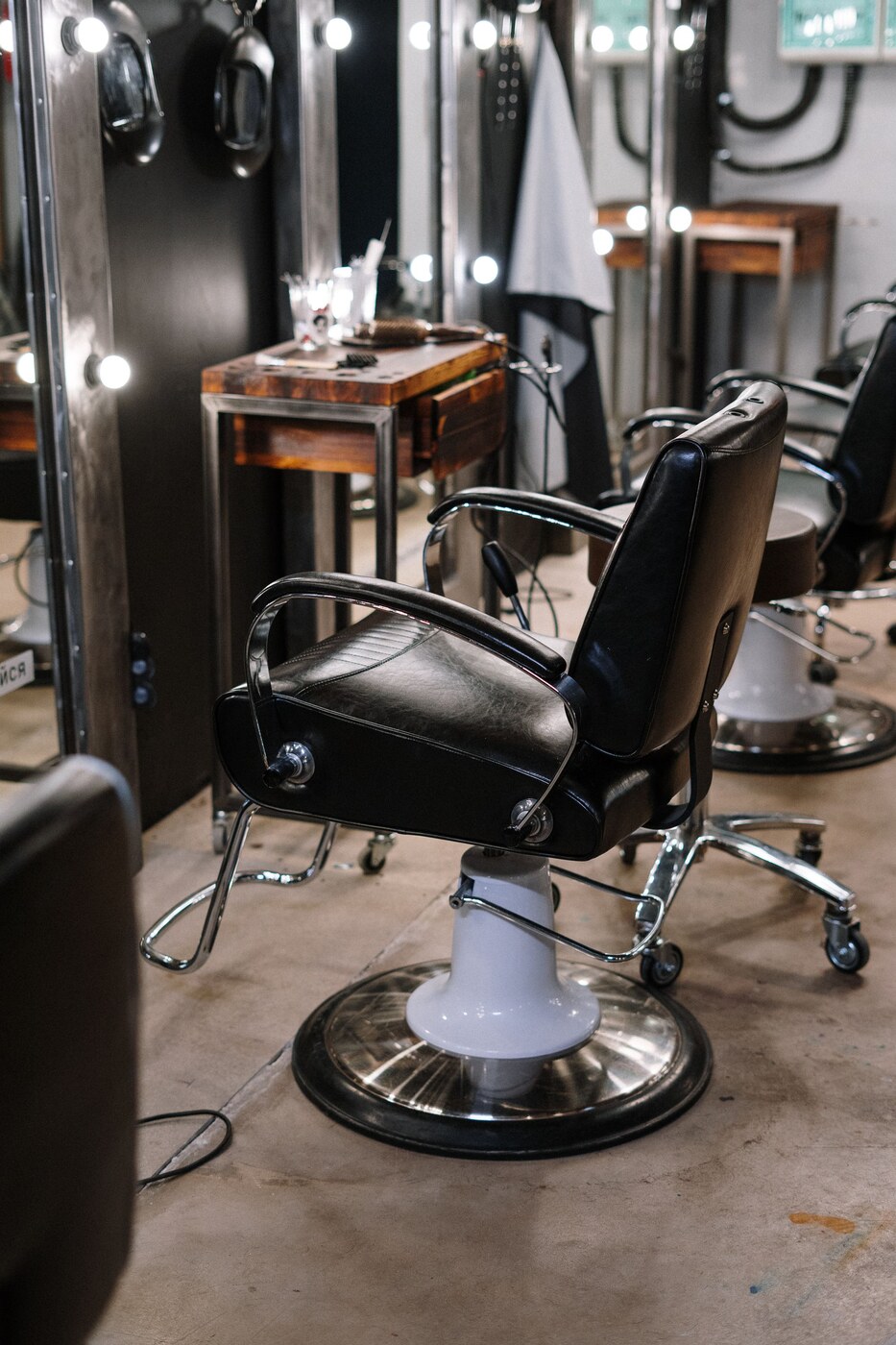 Black salon chairs in front of mirrors; stock photography for a fictional demo